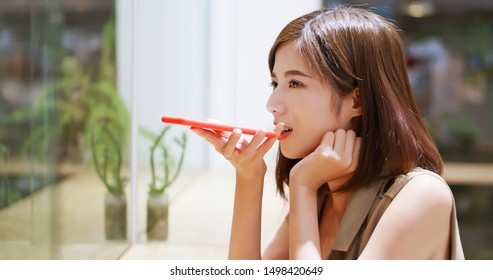 Young woman use vocal assistant by phone in coffee shop - Powered by Shutterstock