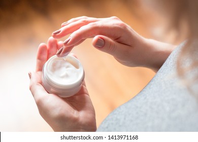 young woman uses body care cream - Shutterstock ID 1413971168