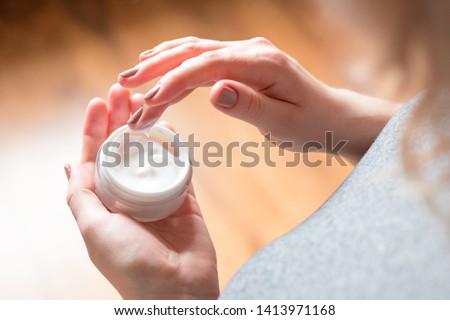 young woman uses body care cream