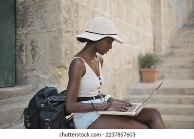 young woman uses a computer in the street - Shutterstock ID 2237857603