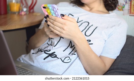 A Young Woman Uses A Smartphone In A Multi-colored Pop-it Case. Hands Only, Selective Focus