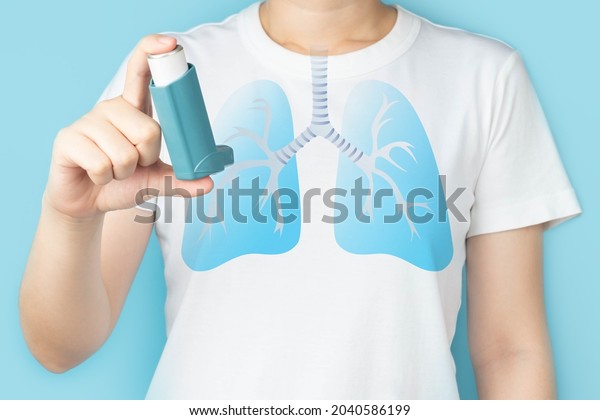 Young woman using blue asthma inhaler for relief\
asthma attack. Pharmaceutical products is used to prevent and treat\
wheezing and shortness of breath caused asthma or COPD. Lung organ\
anatomy.