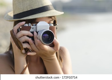 Young Woman Using Camera At The Beach