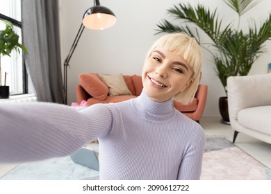 Young Woman Using Camera Of Smartphone Taking Selfie At Cozy Home. Girl Recording A Video Blog Lesson In The Interior Of Her Room Face Headshot.