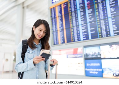 Young woman using cellphone in airport