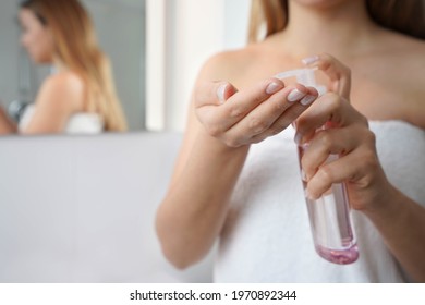Young woman using cleansing oil eco-friendly to remove makeup. Close up of woman hands spraying cleansing oil. Focus on the hand.