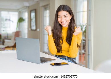 Young woman using computer laptop celebrating surprised and amazed for success with arms raised and open eyes. Winner concept. - Shutterstock ID 1452708770
