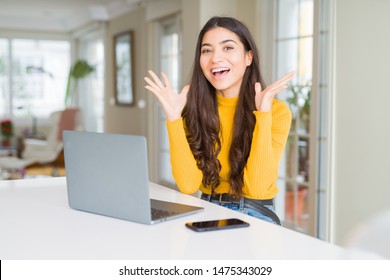 Young woman using computer laptop celebrating crazy and amazed for success with arms raised and open eyes screaming excited. Winner concept - Shutterstock ID 1475343029