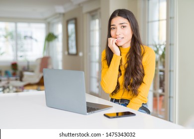 Young woman using computer laptop looking stressed and nervous with hands on mouth biting nails. Anxiety problem. - Shutterstock ID 1475343032