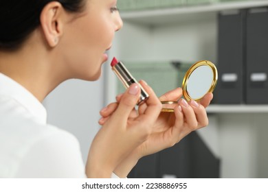 Young woman using cosmetic pocket mirror while applying make up indoors, closeup - Shutterstock ID 2238886955