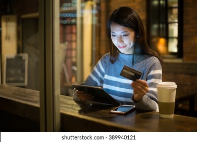 Young Woman Using Credit Card For Paying On Tablet