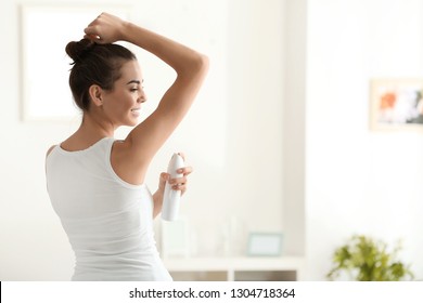 Young Woman Using Deodorant At Home