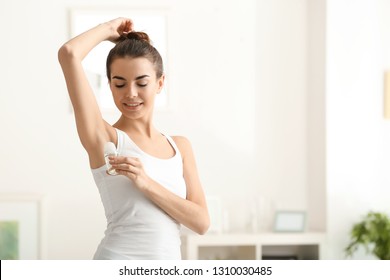 Young Woman Using Deodorant At Home