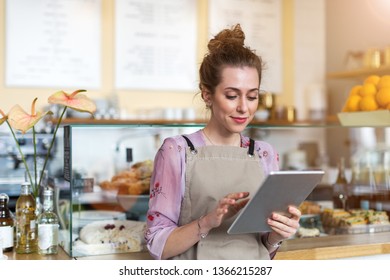 Young woman using digital tablet in coffee shop - Shutterstock ID 1366215287