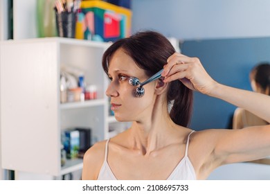 Young Woman Using Facial Roller For Face Massage. Beauty Skin Care