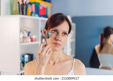 Young Woman Using Facial Roller For Face Massage. Beauty Skin Care