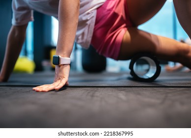 Young woman using a foam roller while doing stretching exercises - Shutterstock ID 2218367995