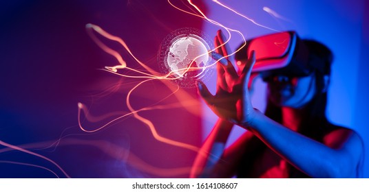 Young woman using glasses of virtual reality on dark background. Smartphone using with VR headset,virtual reality,future technology concept.Asian woman using VR glasses in colorful neon lights. - Powered by Shutterstock