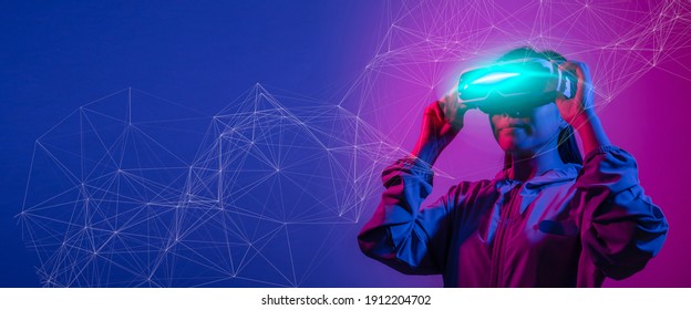 Young woman using glasses of virtual reality on dark background. Smartphone using with VR headset,virtual reality,future technology concept.Asian woman using VR glasses in colorful neon lights. - Shutterstock ID 1912204702