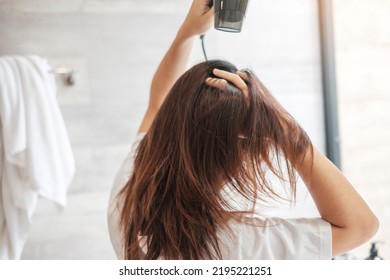 young woman using hair dryer at home or hotel. Hairstyles and lifestyle concepts - Powered by Shutterstock