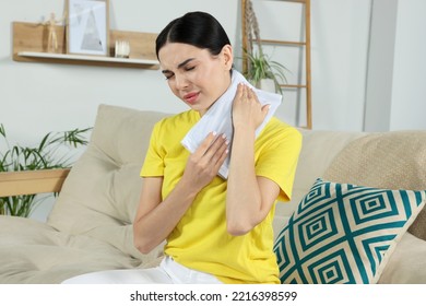 Young Woman Using Heating Pad On Neck At Home