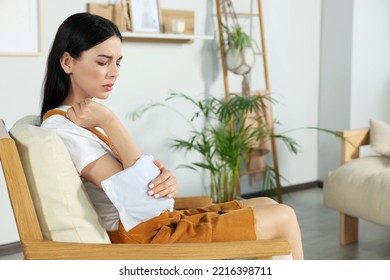 Young Woman Using Heating Pad At Home