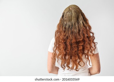 Young Woman Using Henna Hair Dye On Light Background