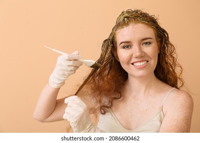 Young Woman Using Henna Hair Dye On Color Background