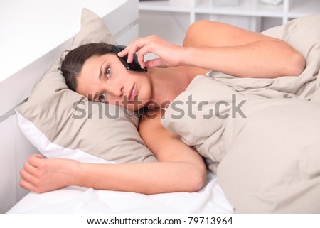 Young woman using her cellphone in bed Stock photo © 