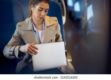 Young Woman Using Her Computer While Commuting To Work By Train.