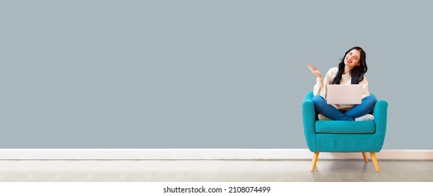 Young Woman Using Her Laptop In A Chair