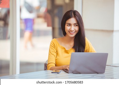 Young woman using laptop computer. Female working on laptop in an outdoor cafe.