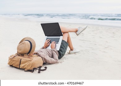 Young woman using laptop computer on a beach. Freelance work, vacations, distance work, social distancing, e-learning, connection, creative professional, new business, meeting online concept - Powered by Shutterstock