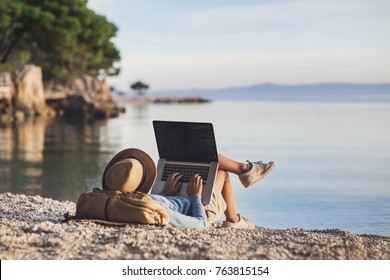 Young woman using laptop computer on a beach. Girl freelancer working by the sea. Freelance work, travel, vacations, stay connected, communication, studying online, e-learning concept - Shutterstock ID 763815154