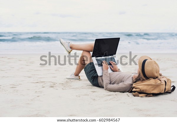 ビーチでノートパソコンを使う若い女性 フリーランスの仕事のコンセプト の写真素材 今すぐ編集