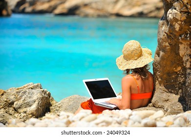 Young Woman Using Laptop On The Beach