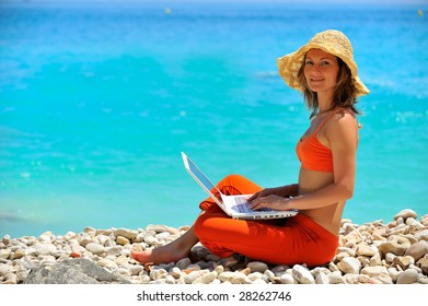 Young Woman Using Laptop On The Beach