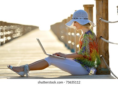 Young Woman Using Laptop Outdoor In Summer