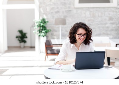 Young woman using laptop for webinar, video conference. Freelancer talking on virtual call and online meeting. Girl working in in coworking office. Connection, communication with social distance. - Powered by Shutterstock