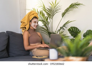 Young Woman Using Laptop While Having Skin Care Day At Home 