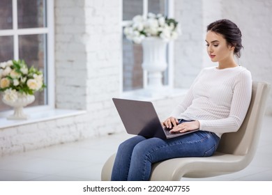 Young Woman Using Laptop While Sitting On Fancy Chair