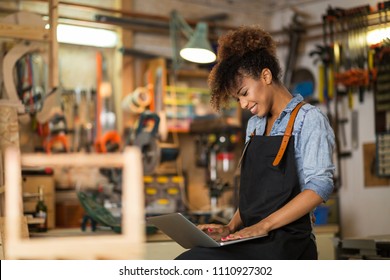 Young woman using a laptop in a workshop - Powered by Shutterstock