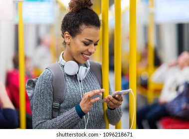 Young Woman Using Mobile Phone On Subway