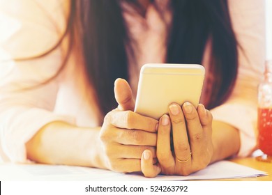 Young Woman Using Mobile Phone To Play On Social Media And Checking Website, Relaxing During A Break From Working At Coffee Shop And Feeling Friendly To Use Online Technology For Shopping 