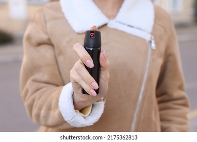 Young Woman Using Pepper Spray Outdoors, Closeup