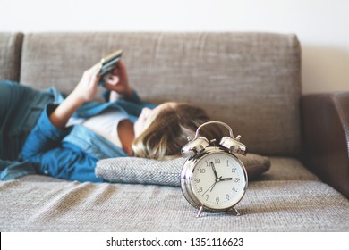 Young Woman Using Phone In Bed, Looking At Screen, Insomnia, Check Time, Wake Up With Smartphone, Mobile Phone Addiction - Alarm Clock Near