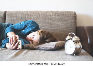 Young Woman Using Phone In Bed, Looking At Screen, Insomnia, Check Time, Wake Up With Smartphone, Mobile Phone Addiction - Alarm Clock Near