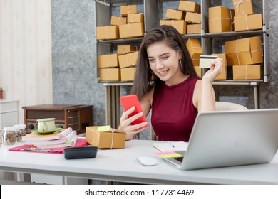 Young Woman Using A Phone And A Credit Card For Online Purchases. To Build Private Business.