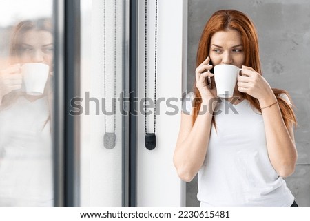 Young woman using phone and enjoying coffe break at home