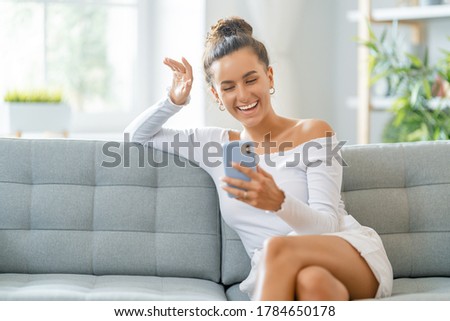 Young woman is using phone for video call. Funny girl having fun staying at home.